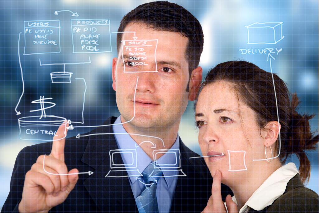 A man and a woman looking at a software design diagram on a transparent screen